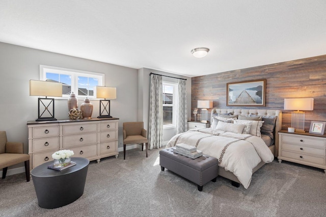 carpeted bedroom featuring multiple windows and wooden walls