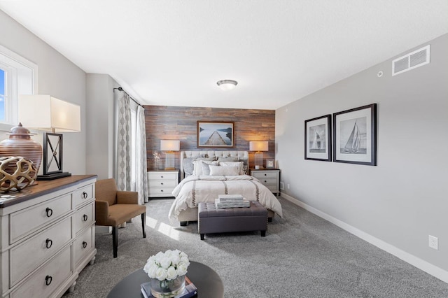 bedroom with light colored carpet and wooden walls