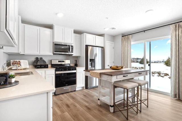 13647 Kaylemore Trl, Rosemount, MN 55068 - kitchen featuring stainless steel appliances, light wood-style flooring, white cabinets, light countertops, and recessed lighting