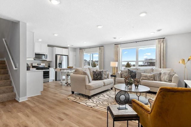 13647 Kaylemore Trl, Rosemount, MN 55068 - living room with stairs, light wood-type flooring, recessed lighting, and a textured ceiling