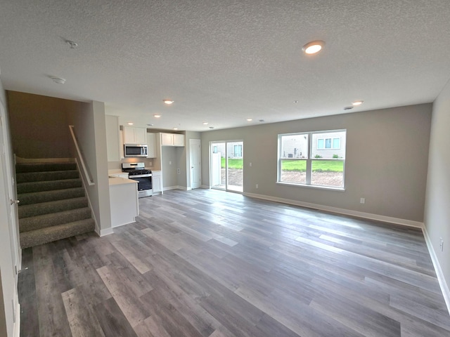13647 Kaylemore Trl, Rosemount, MN 55068 - unfurnished living room with a textured ceiling, light wood-style floors, stairway, and recessed lighting