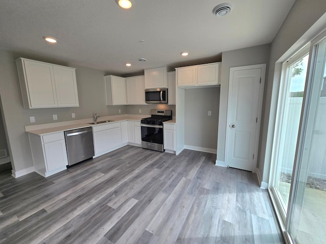 13647 Kaylemore Trl, Rosemount, MN 55068 - kitchen with appliances with stainless steel finishes, white cabinets, light wood-style floors, light countertops, and recessed lighting