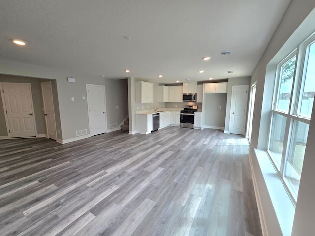 13647 Kaylemore Trl, Rosemount, MN 55068 - unfurnished living room featuring light wood-type flooring, stairway, and recessed lighting