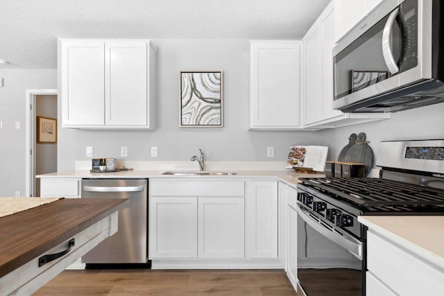 13647 Kaylemore Trl, Rosemount, MN 55068 - kitchen featuring stainless steel appliances, white cabinets, light wood finished floors, and a textured ceiling