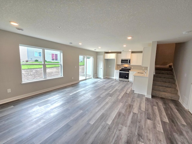 13651 Kaylemore Trl, Rosemount, MN 55068 - unfurnished living room with a textured ceiling, wood finished floors, stairway, and recessed lighting