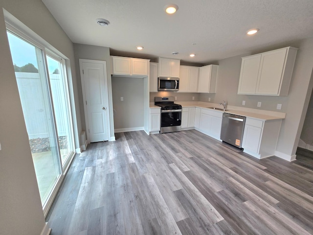 13651 Kaylemore Trl, Rosemount, MN 55068 - kitchen with stainless steel appliances, white cabinets, light wood-style floors, light countertops, and recessed lighting