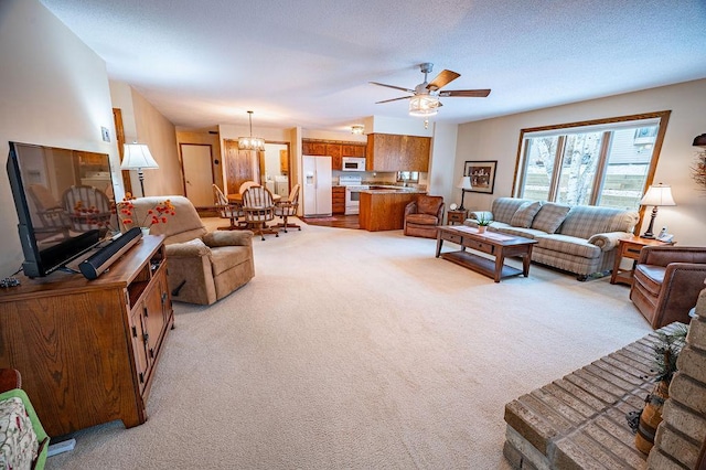 living room featuring light colored carpet, ceiling fan with notable chandelier, and a textured ceiling