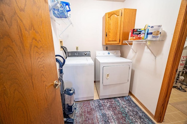 clothes washing area with independent washer and dryer, cabinets, and water heater