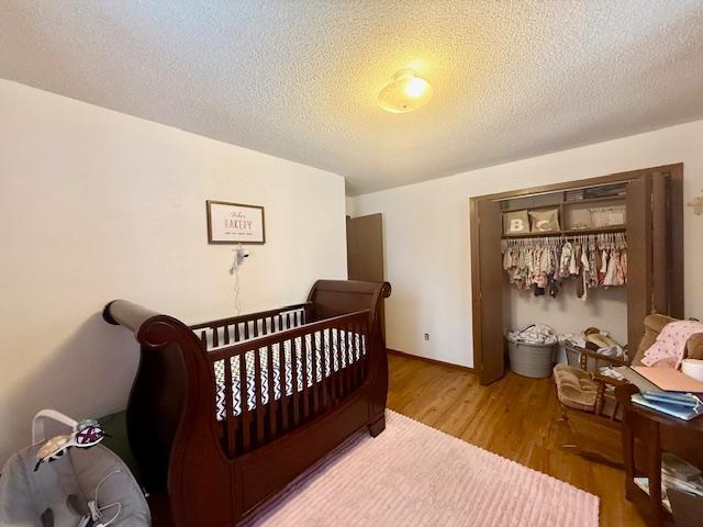 bedroom featuring a textured ceiling and wood finished floors