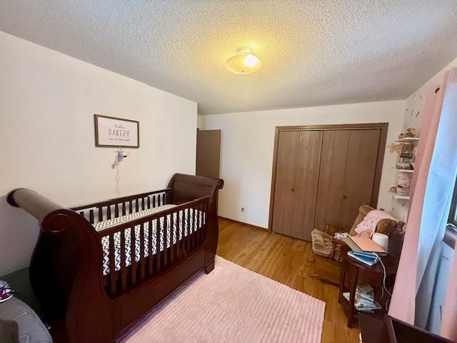bedroom featuring a closet, a textured ceiling, and wood finished floors