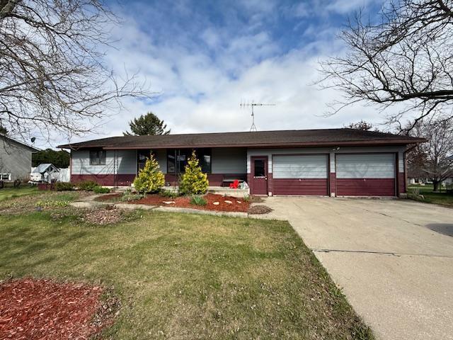 ranch-style house with an attached garage, driveway, a front lawn, and brick siding