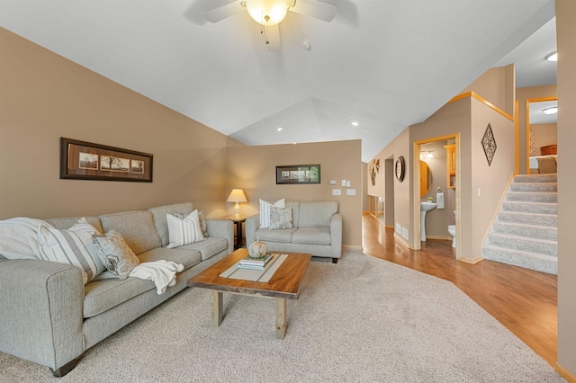 living room with ceiling fan, lofted ceiling, and light hardwood / wood-style flooring