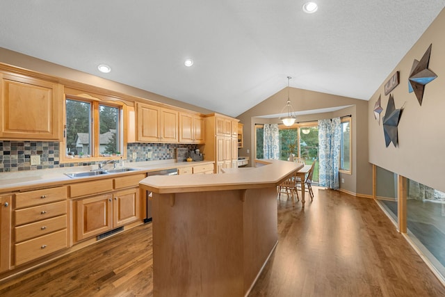 kitchen featuring a kitchen island with sink, sink, stainless steel dishwasher, and light brown cabinets