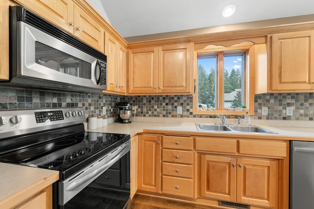 kitchen featuring appliances with stainless steel finishes, sink, and decorative backsplash