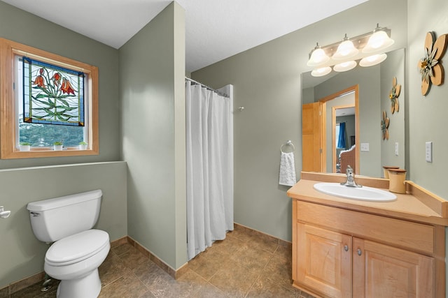 bathroom featuring vanity, walk in shower, and toilet