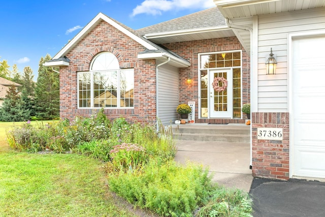 entrance to property featuring a lawn