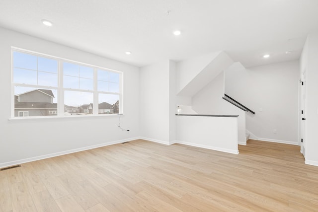 interior space with light wood finished floors, recessed lighting, visible vents, stairway, and baseboards