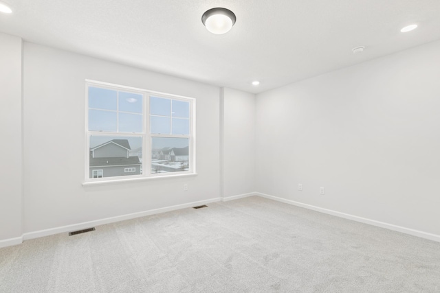 carpeted spare room with recessed lighting, visible vents, and baseboards