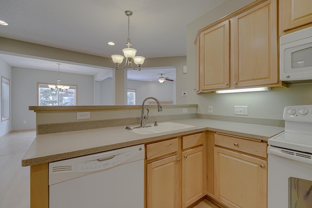 kitchen featuring light brown cabinetry, sink, decorative light fixtures, kitchen peninsula, and white appliances