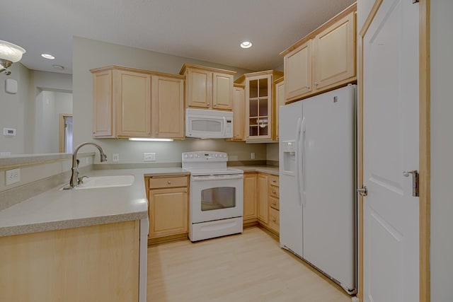 kitchen featuring sink, white appliances, light hardwood / wood-style floors, and light brown cabinets