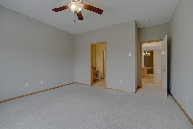 unfurnished bedroom featuring ensuite bath, ceiling fan with notable chandelier, and light carpet