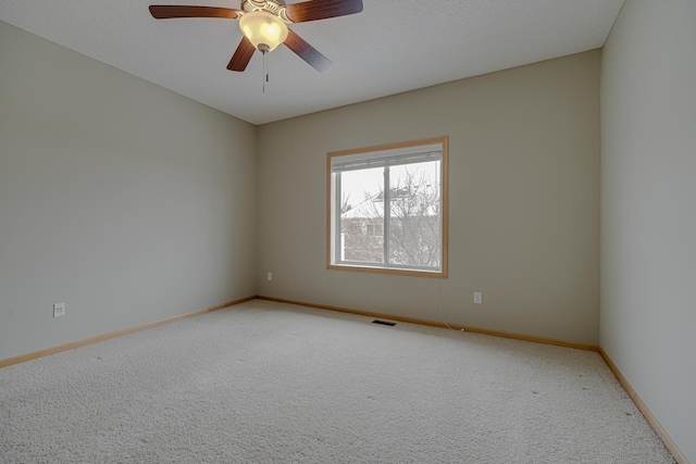 carpeted empty room featuring ceiling fan and a textured ceiling