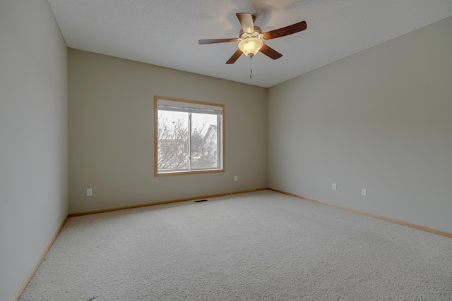 carpeted spare room with ceiling fan and a textured ceiling