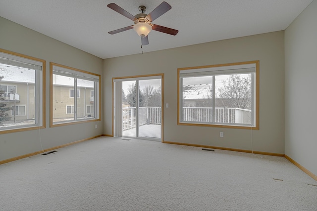 unfurnished room with ceiling fan, carpet flooring, and a textured ceiling