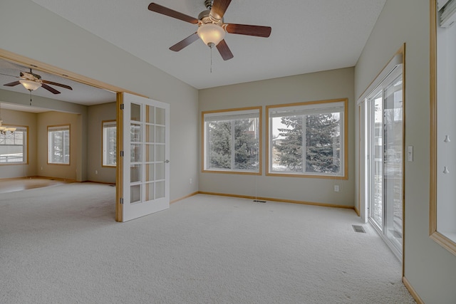 unfurnished room with ceiling fan, plenty of natural light, and light carpet