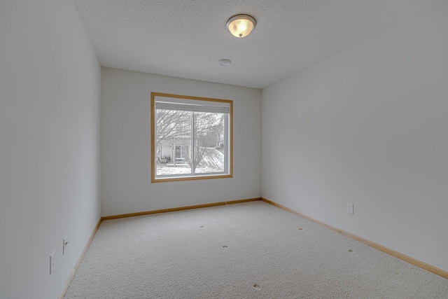 unfurnished room with light colored carpet and a textured ceiling