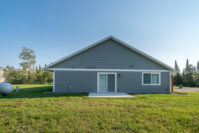 back of property featuring a patio area and a yard