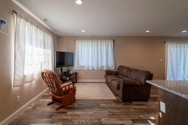 living room featuring dark wood-style floors, baseboards, visible vents, and recessed lighting