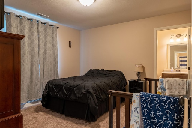 bedroom featuring carpet, a sink, and visible vents