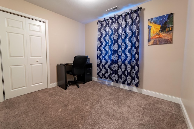 carpeted office space featuring visible vents and baseboards