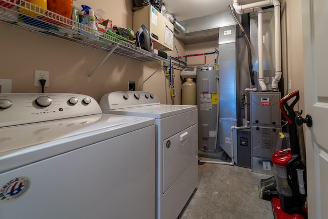 clothes washing area featuring laundry area, electric water heater, and washer and clothes dryer