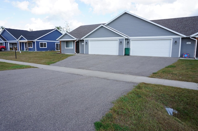 ranch-style house with aphalt driveway, a front lawn, and roof with shingles