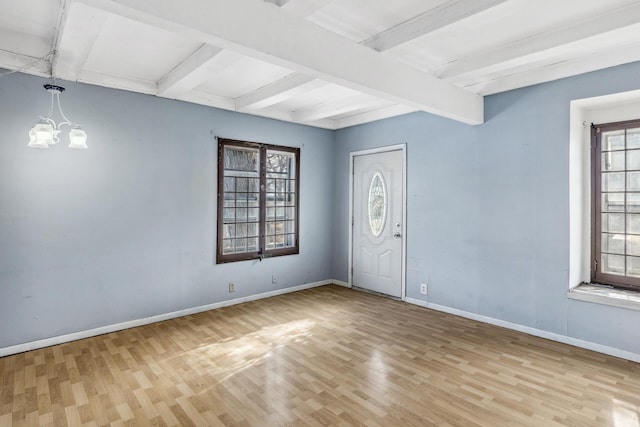 foyer featuring baseboards, a chandelier, light wood-style flooring, and beamed ceiling