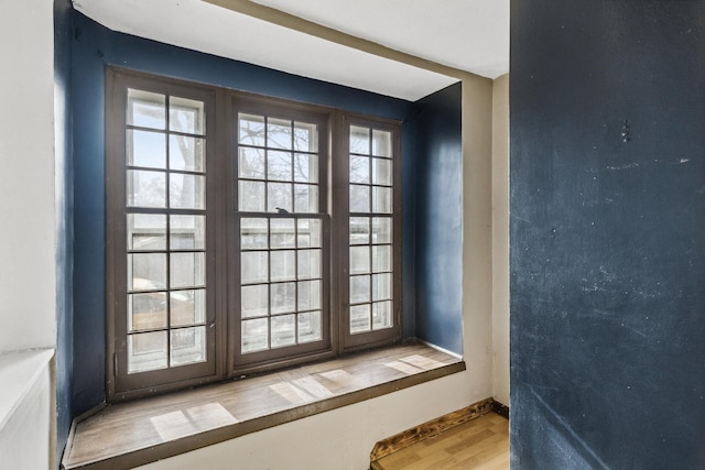 doorway to outside featuring baseboards and wood finished floors