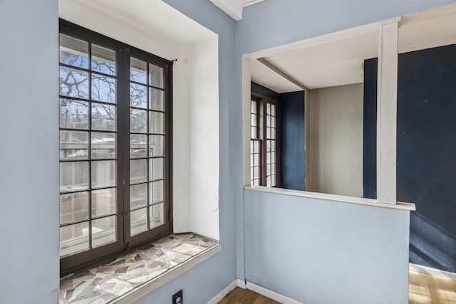 doorway featuring baseboards and wood finished floors