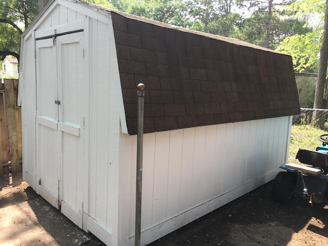 view of shed featuring fence