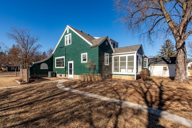 exterior space featuring cooling unit, a yard, and a sunroom