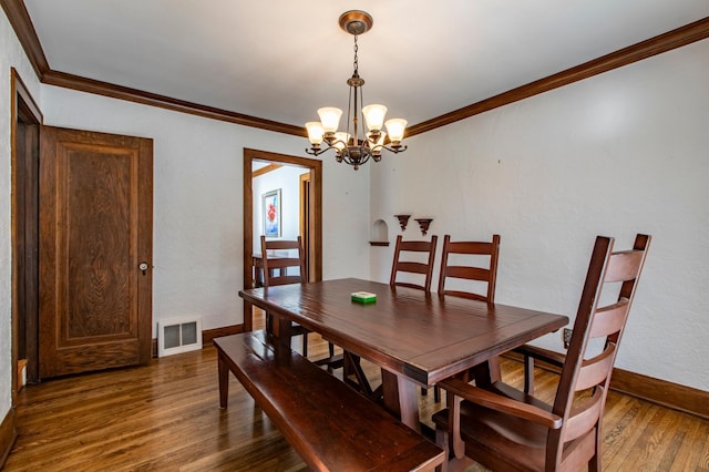 dining room with ornamental molding, dark wood-type flooring, and an inviting chandelier