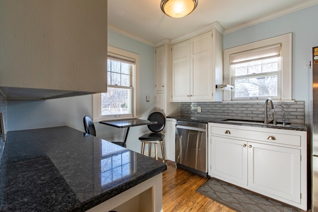 kitchen with backsplash, white cabinets, stainless steel dishwasher, crown molding, and light wood-type flooring