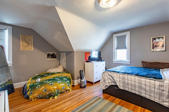 bedroom with vaulted ceiling and light hardwood / wood-style floors