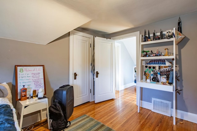 bedroom featuring vaulted ceiling and light wood-type flooring