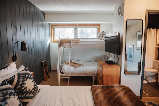 bedroom featuring wooden walls and a textured ceiling