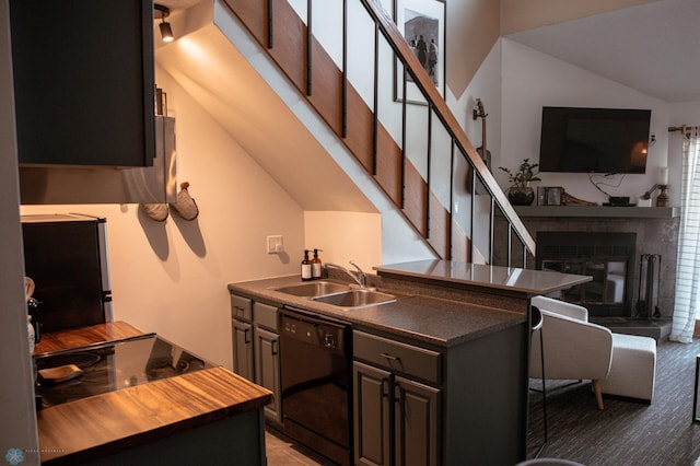 kitchen featuring vaulted ceiling, black dishwasher, sink, and light colored carpet