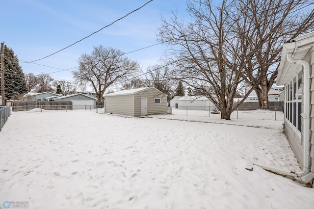 yard covered in snow with a storage shed