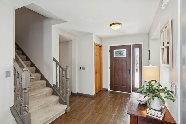 foyer with dark hardwood / wood-style flooring and a textured ceiling