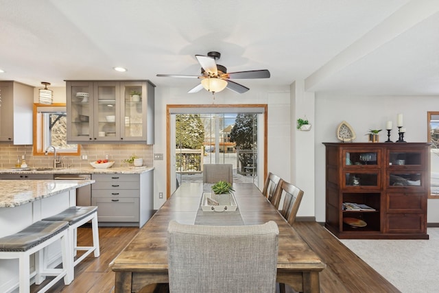 dining space with ceiling fan, sink, and light hardwood / wood-style floors